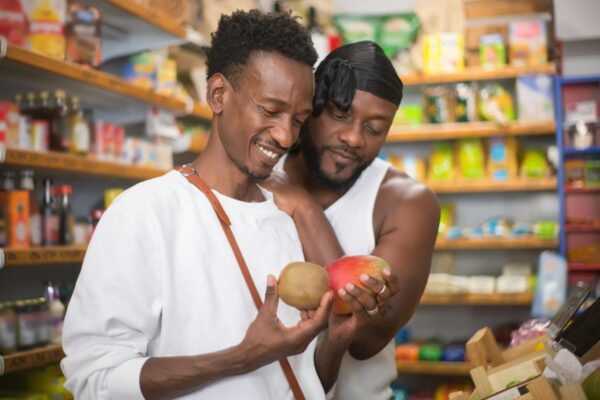 Happy couple choosing fruits in a local grocery store in Portugal.